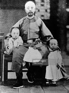 an old black and white photo of a man with two children