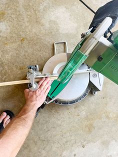 a man is using a machine to cut glass with a wooden dowl and some other tools