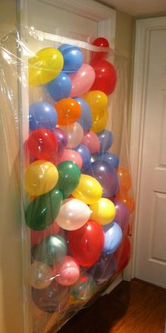 a bunch of balloons are in a plastic bag on the floor next to a door