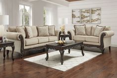 a living room filled with furniture on top of a hard wood floor covered in white rugs