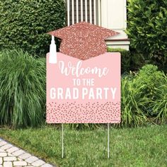 a welcome to the grad party sign with a graduation cap on it in front of some bushes