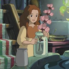 a woman holding a jar with flowers in it next to stacks of books and papers