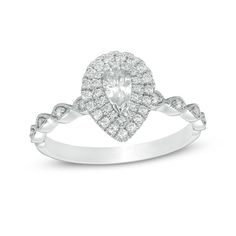 a white gold ring with diamonds on the band and a pear shaped diamond in the center