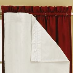 red and white curtains hanging on the side of a window