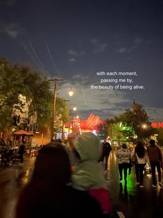 people walking down the street at night with an inspirational quote on the back ground above them