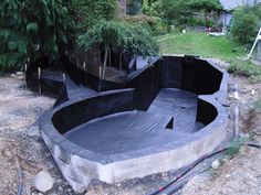 an above ground pool is being built in the backyard with trees and bushes around it