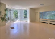 an empty room with large windows and white floors