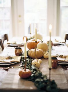 the table is set with candles and pumpkins