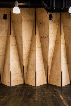 wooden panels are lined up against the wall in an empty room with three lamps on each side