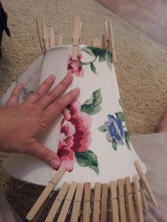 a person is holding an object made out of clothes pins and fabric with flowers on it