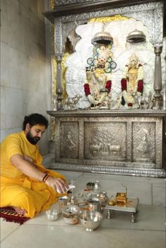 a man sitting on the ground in front of a shrine