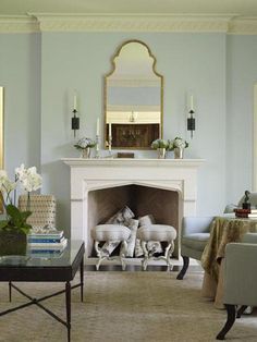 a living room filled with furniture and a fire place in front of a white fireplace