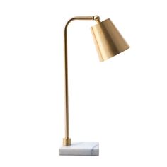 a gold and white lamp on a marble base with a brass shade over it's head