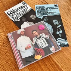 two cd's sitting on top of a wooden table