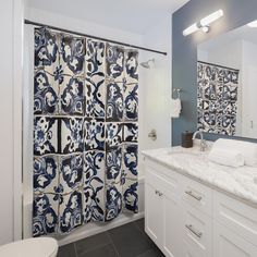 a bathroom with blue and white tiles on the shower curtain next to the sink area