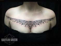 a woman's chest with an intricate tattoo design on her left shoulder and breast