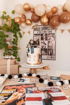 a birthday cake sitting on top of a table next to balloons and other decorations in the background