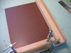 a wooden box with two metal handles on top of it and a pair of scissors next to it