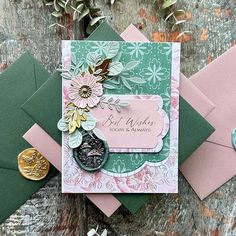 a close up of a greeting card with flowers on it and two envelopes next to each other