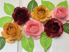 paper flowers arranged on top of each other with green leaves and red, pink, yellow and orange flowers