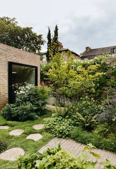 an outdoor garden with stepping stones and grass