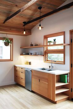 an image of a kitchen with wood cabinets and white counter tops on the bottom shelf