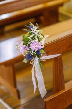 a bouquet of flowers sitting on the pews of a church