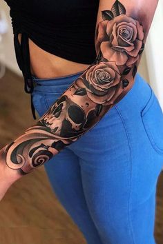 a woman's arm with roses and skulls tattooed on the side of her body