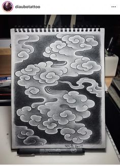 a black and white drawing of clouds in the sky on a notepad with an instagram caption above it