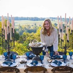 a woman sitting at a table with blue dishes on it