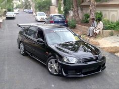 a black car parked on the side of a street