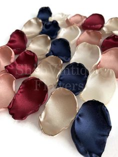 many different colors of satin fabric on a white surface