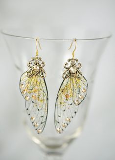 "The Golden Hour Fairy Wing earrings are part of our new Bridal Collection! These gorgous earrings are made with our hyper halo gold dusted shimmer and flecked with Gold leaf flakes that shimmer as they catch the light, and accented with golden toned crystals. These would be simply breathtaking with a wedding gown! The ear wires are nickle free, lead free gold plated. Earrings are 2\" long. These earrings are so stunning in person, we combined our love art nouveau and fairy magic to create this Fairy Wing Earrings, Art Nouveau Earrings, Art Nouveau Earring, The Golden Hour, Surgical Steel Earrings, Fairy Magic, Fairy Wings, Wing Earrings, Brass Earrings