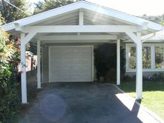 a house with a white roof and two cars parked in front of the garage door