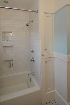 a white bathroom with a tub and shower