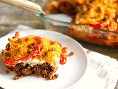 a slice of lasagna casserole on a plate next to a casserole dish