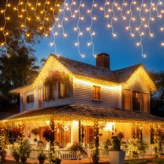 a house with christmas lights hanging from it's roof and on the front porch