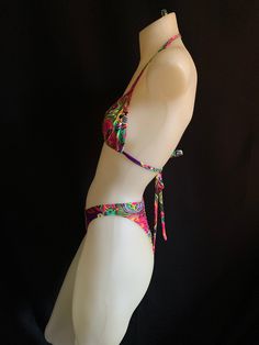 "70's and 80s style string bikini with high leg! Mannequin is a size small and A/B cup for reference. Bra top is lined but not padded for comfort. Bottoms are lined and can be made as a thong, tanga or full coverage (shown). Sizing- PLEASE DOUBLE CHECK YOUR SIZE BELOW BEFORE PLACING AN ORDER. If you send me your measurements (waist, hip and cup size) that would ensure a proper fit. If you need different sizes for the top and bottom, just leave a note in your order. XX small Bust 28 \"- 30 \" A/B Beach Swimwear With Triangle Top And Boning, Beach Swimwear With Boning And Triangle Top, Multicolor Party Swimwear With Tie-side Bottom, Adjustable T-back Swimwear For Festivals, Festival Fitted Beachwear Swimwear, Tropical Party Swimwear With Tie-side Bottom, Tropical Tie-side Bottom Swimwear For Parties, Triangle Top Swimwear With Boning For Vacation, Triangle Top Swimwear With Boning For Sunbathing