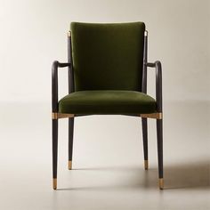 an upholstered green chair with gold trimmings on the arms and back