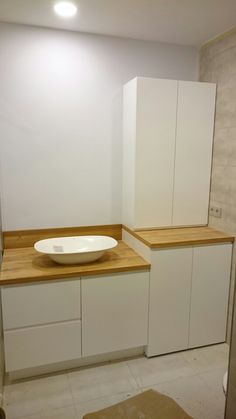 a white bowl sitting on top of a counter in a bathroom next to a sink