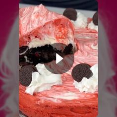 an oreo cookie cake with red frosting and white icing on a plate