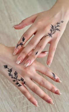 two hands with tattoos on their fingers