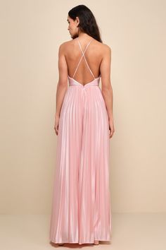 the back of a woman wearing a pink dress with straps and pleating on it