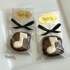 two chocolates wrapped in cellophane and tied with black ribbon