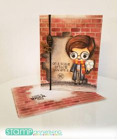 a handmade card with an image of a boy holding a flower in front of a brick wall