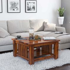 a living room with a couch, coffee table and pictures on the wall