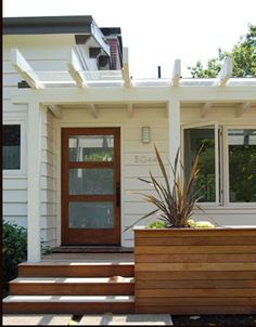 a white house with wooden steps leading up to the front door