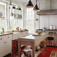 a kitchen with an island in the middle and lots of pots on top of it