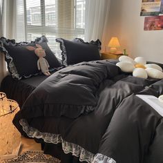 a bed with black comforter and pillows on it