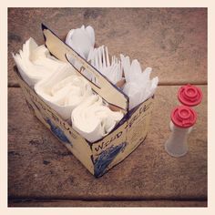 a box filled with lots of white cake next to a red object on the ground